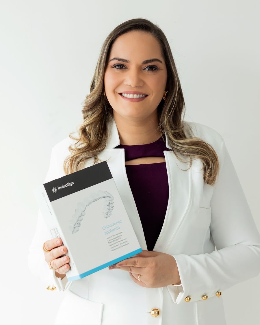 Dra. Adriana Britto segurando a caixa dos alinhadores Invisalign
